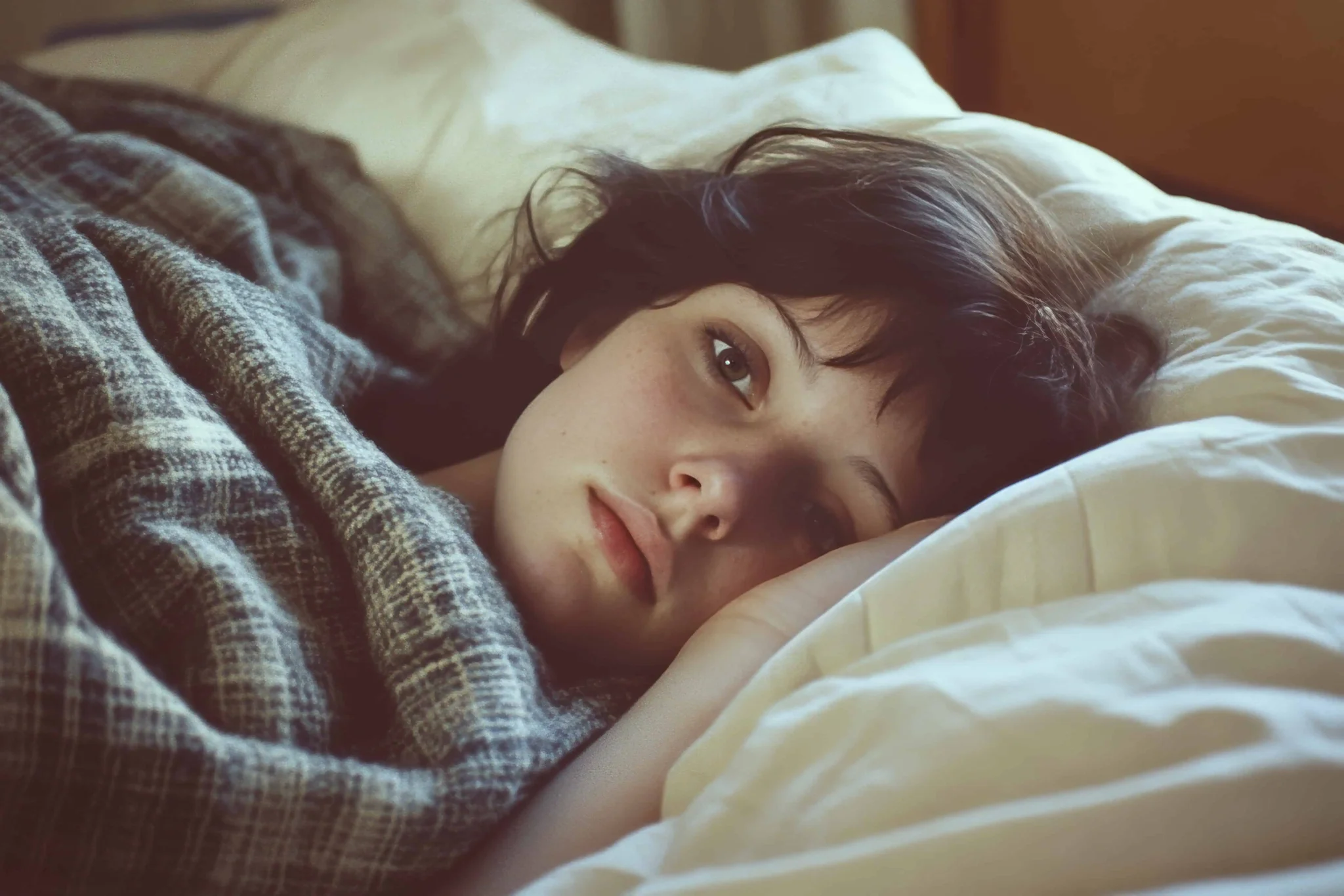 mujer sufriendo de insomnio acostada